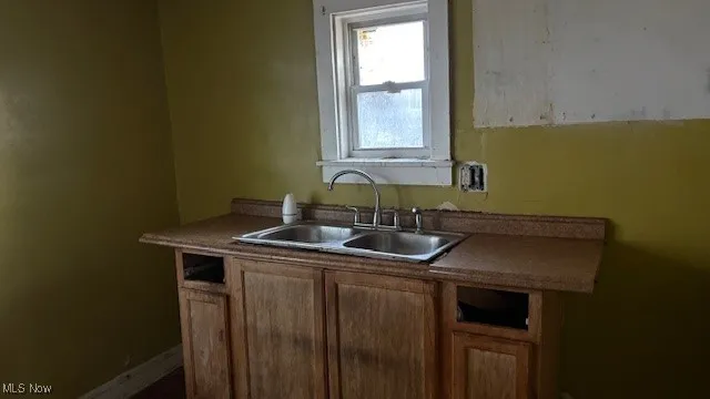 Kitchen featuring a sink and dark countertops