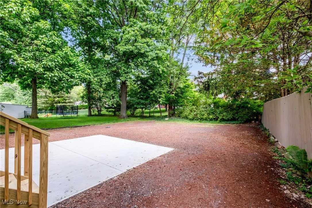 View of yard featuring a trampoline and a patio