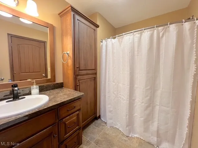 Bathroom with vanity and curtained shower
