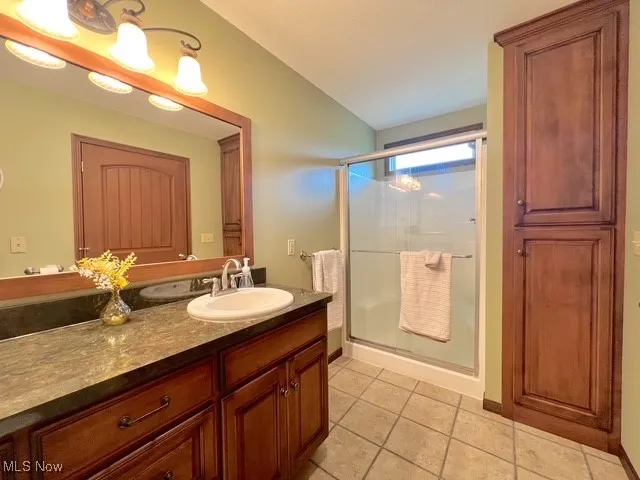 Full bath featuring vanity, a shower stall, and light tile patterned floors