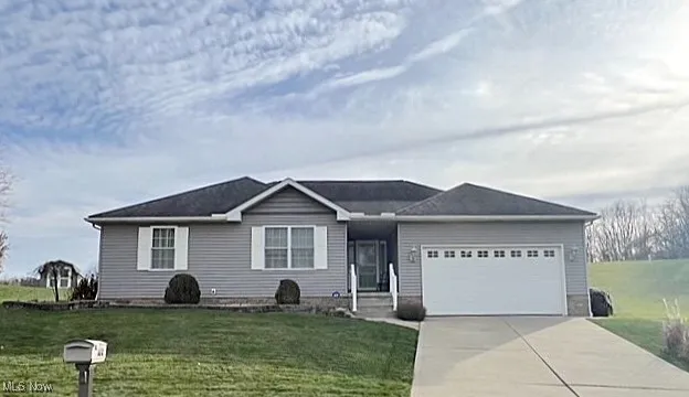 Ranch-style house with an attached garage, a front lawn, and concrete driveway