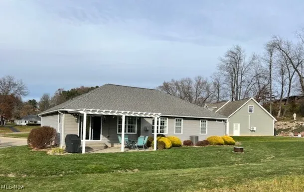 Back of house featuring a patio, a yard, and a pergola