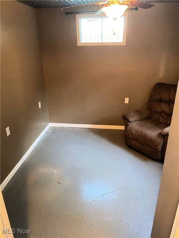 Living area featuring baseboards and finished concrete flooring