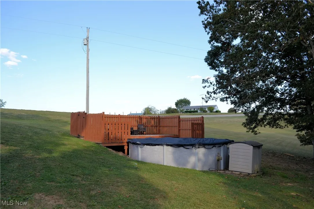 View of grassy yard with a covered pool