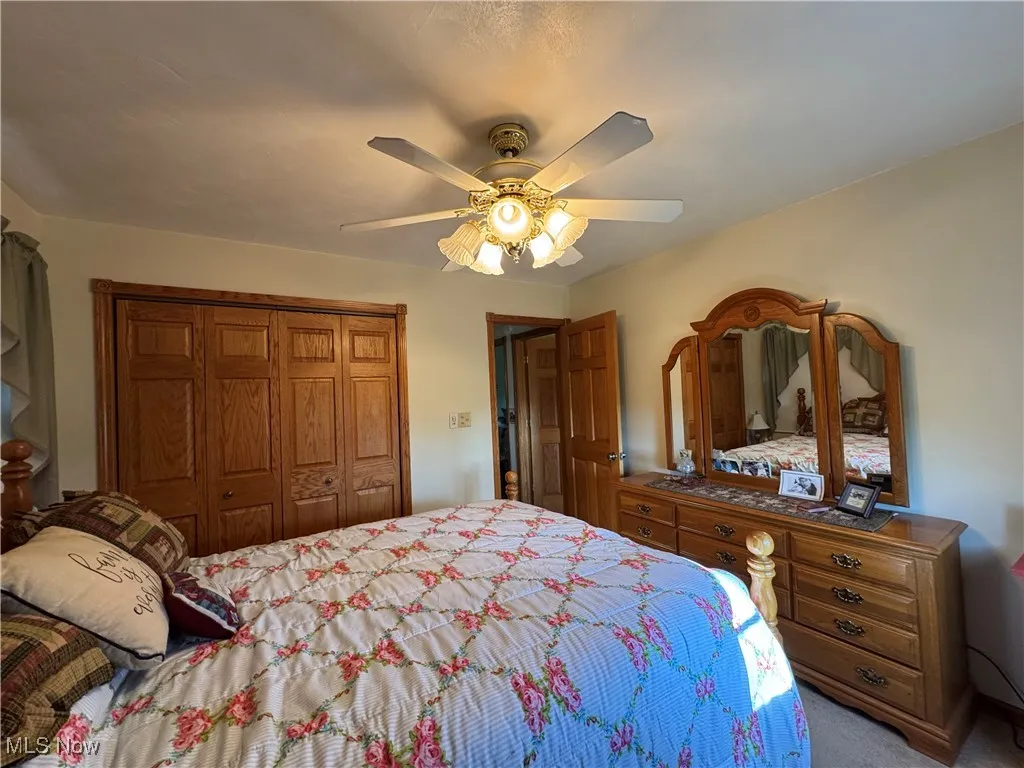 Bedroom with a closet, ceiling fan, and carpet