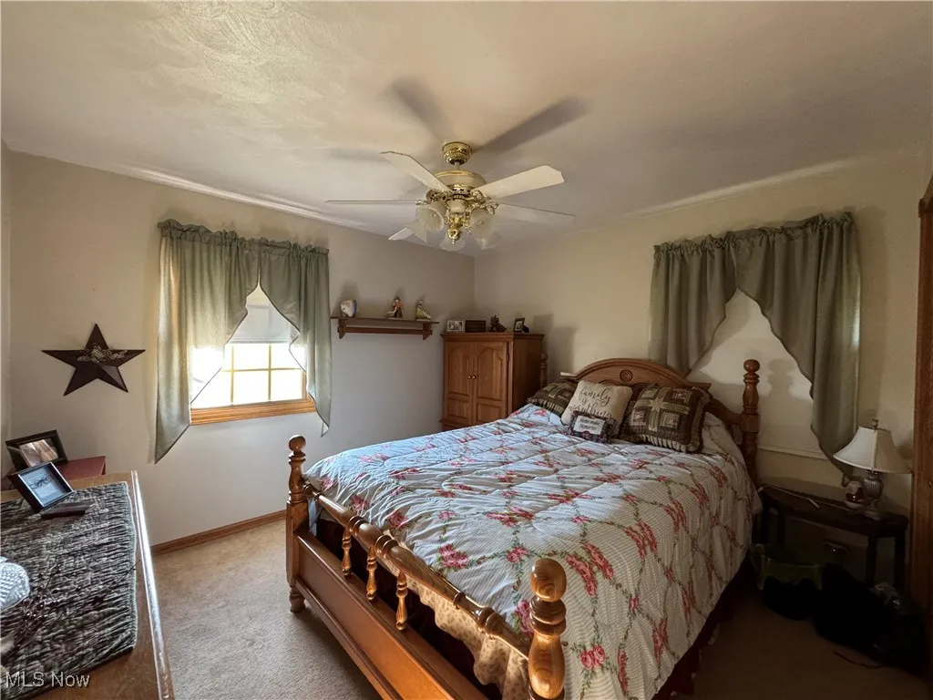 Bedroom featuring light colored carpet and ceiling fan