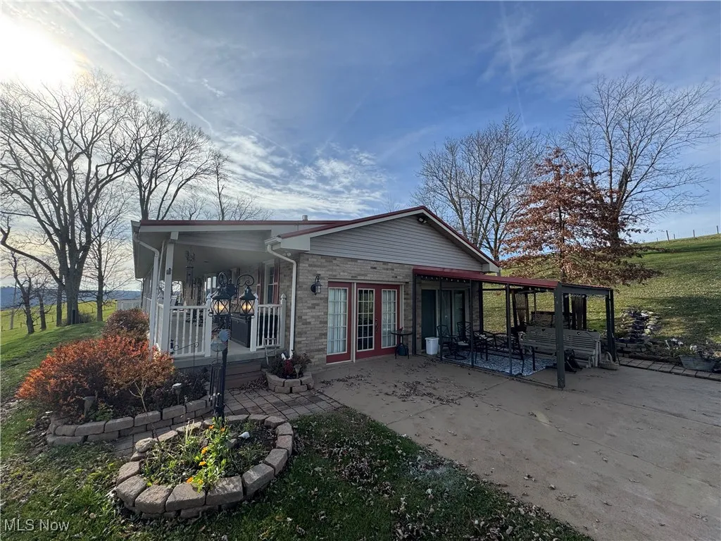 Rear view of property featuring brick siding, french doors, and a yard