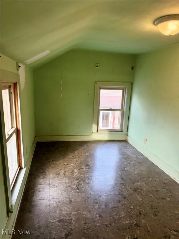 Additional bedroom space featuring tile patterned floors and vaulted ceiling