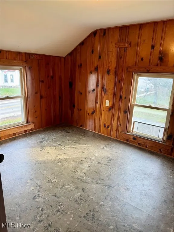 Bedroom featuring ceiling and wood walls