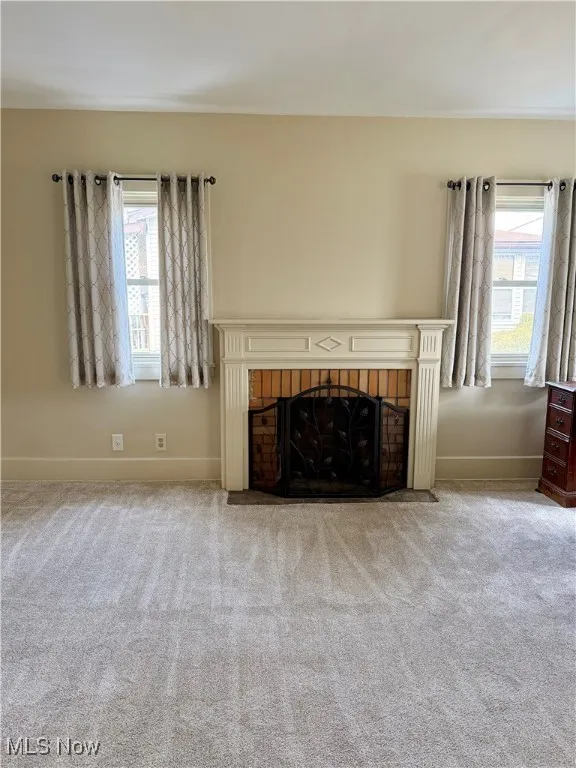 living room with a fireplace and carpet flooring
