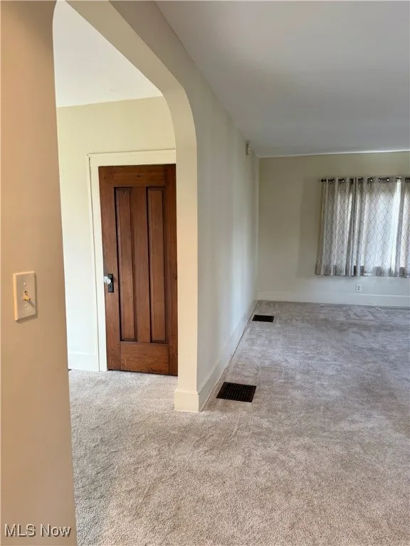 Living room with carpet flooring and arched walkways