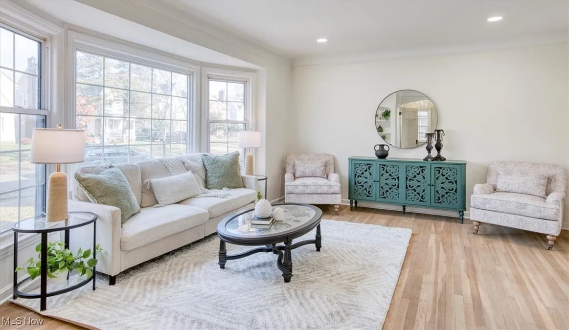 Living area featuring light wood-style flooring, ornamental molding, and recessed lighting