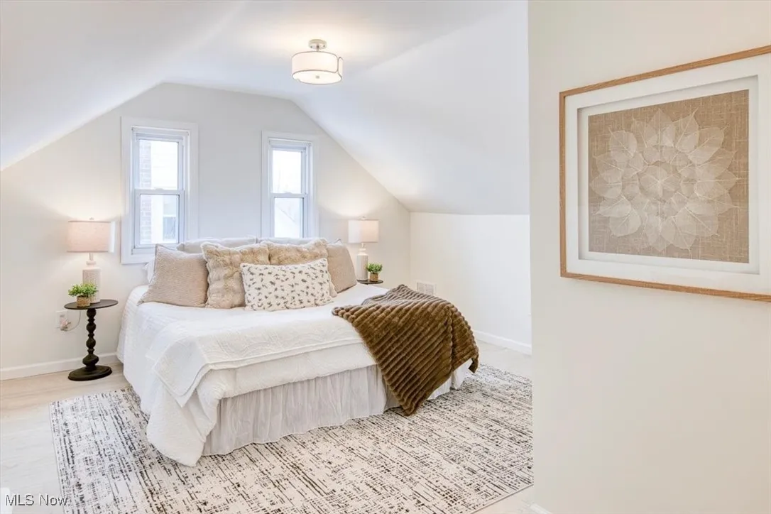 Bedroom with vaulted ceiling and wood finished floors