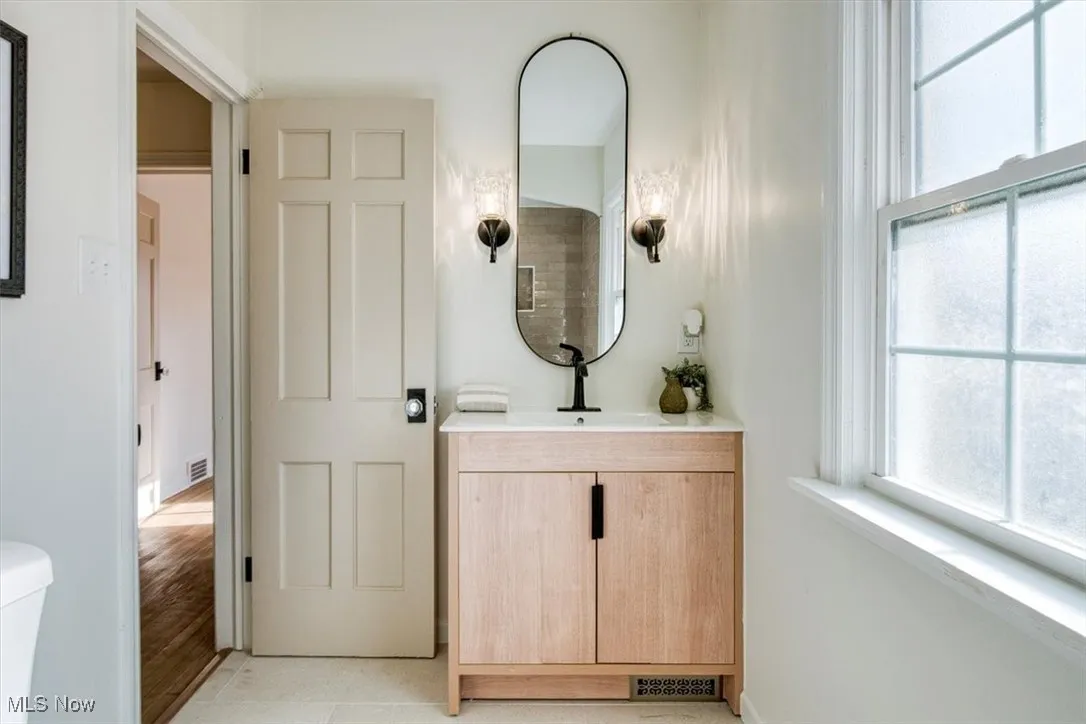 Half bathroom featuring vanity and plenty of natural light