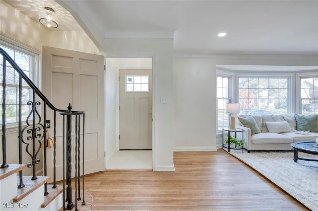 Entryway with light wood-style flooring, stairway, crown molding, and recessed lighting