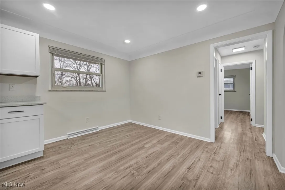 Unfurnished dining area featuring a baseboard heating unit, light wood-style flooring, and recessed lighting