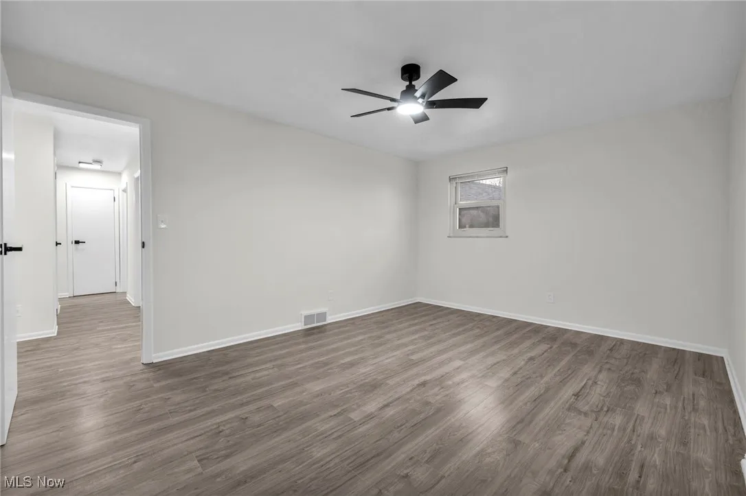 Empty room featuring wood finished floors and a ceiling fan