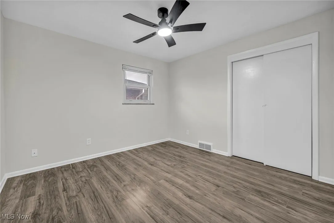 Unfurnished bedroom featuring wood finished floors, a ceiling fan, and a closet