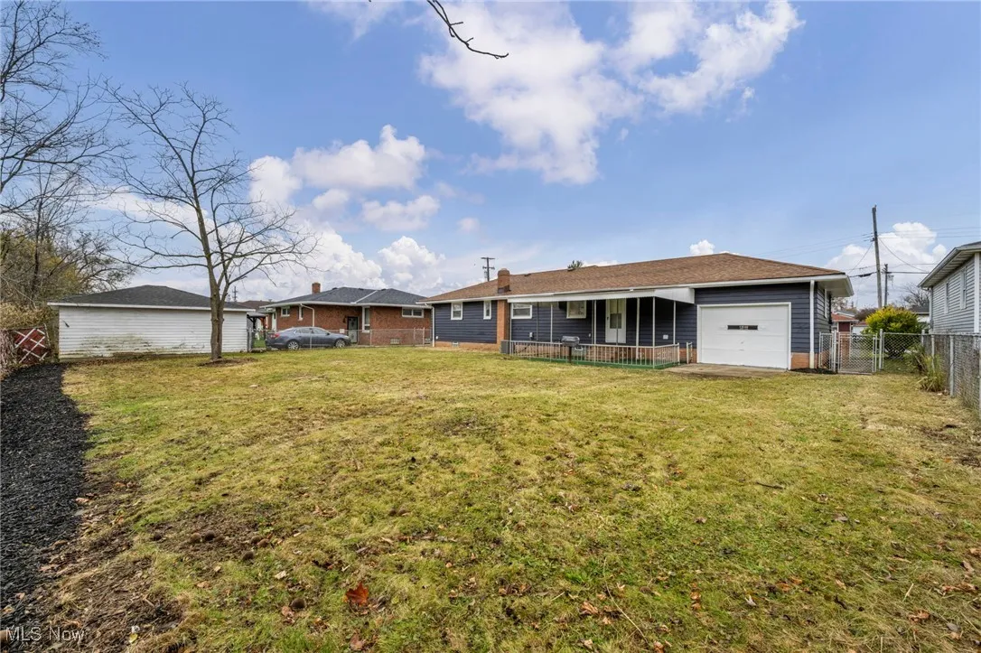 Back of house with an attached garage and a fenced backyard