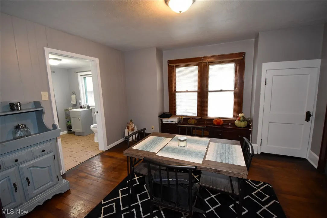 Dining space with dark wood-type flooring and baseboards