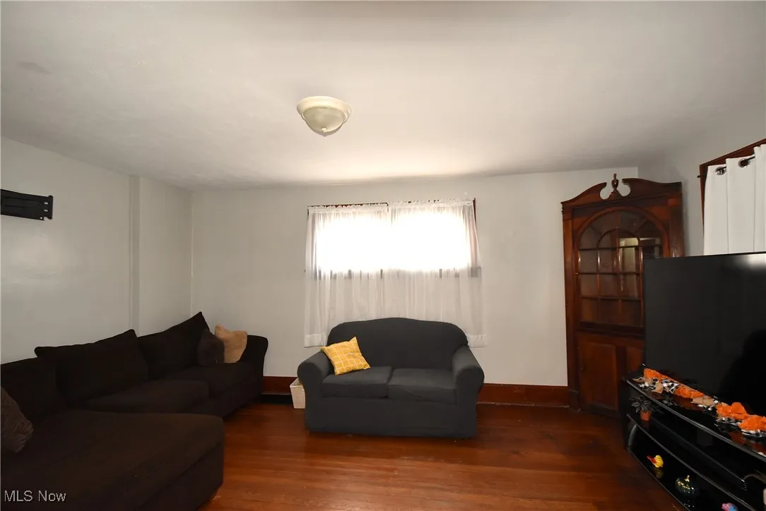 Living room with dark wood finished floors and baseboards
