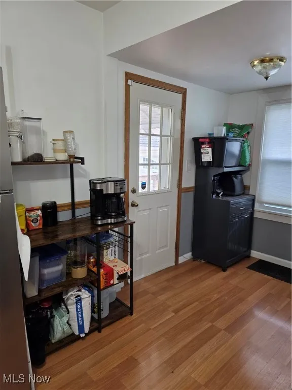Doorway to outside with wood finished floors and baseboards