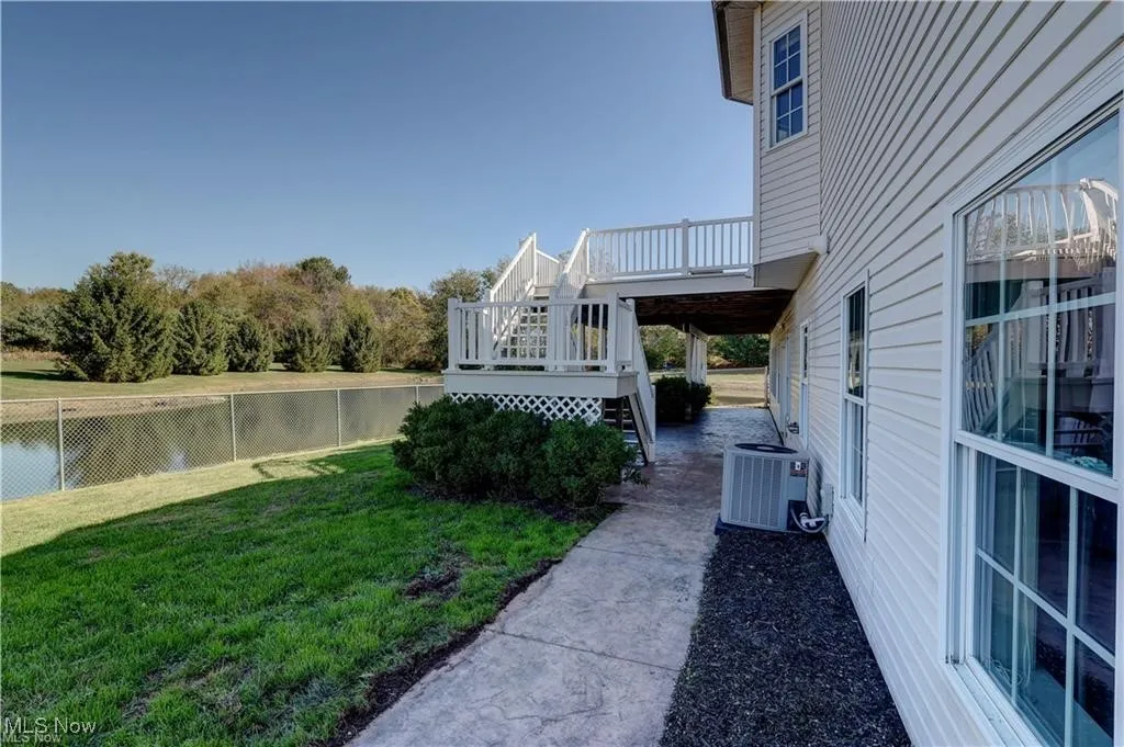 Fenced backyard with stairs and a deck with water view