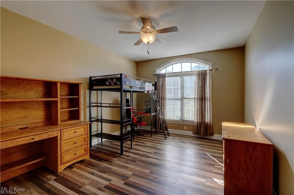 Bedroom with an office area, dark wood finished floors, and ceiling​​‌​​​​‌​​‌‌​‌‌​​​‌‌​‌​‌​‌​​​‌​​ fan