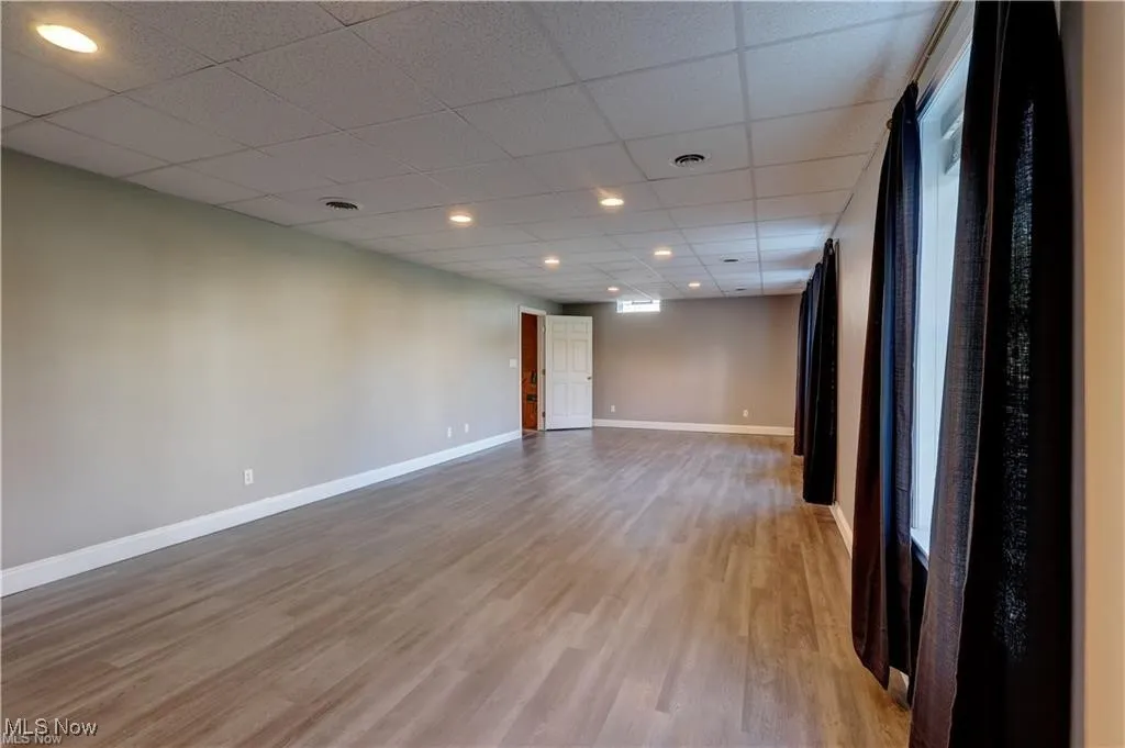 Empty room featuring a drop ceiling, light wood-style flooring, and recessed lighting