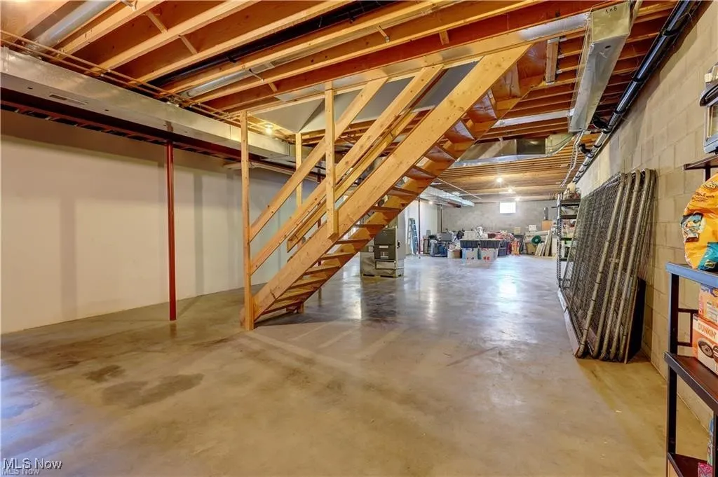 Unfinished below grade area featuring stairway