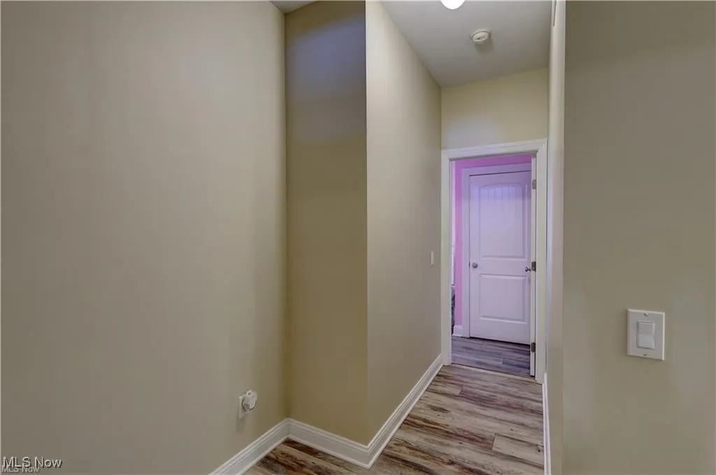Hallway featuring light wood finished floors and baseboards
