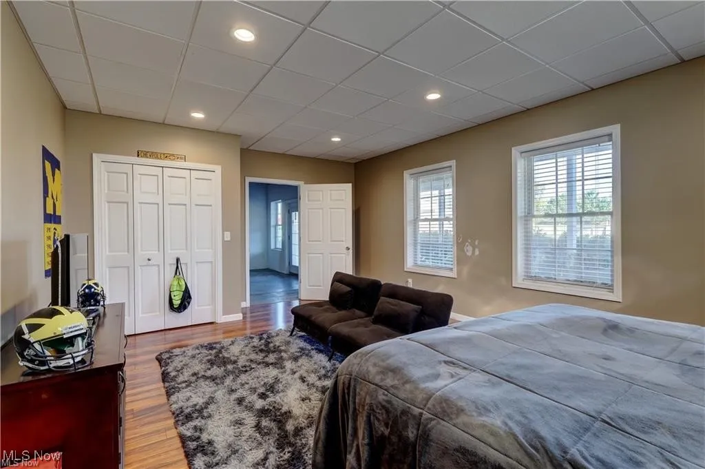 Bedroom with a paneled ceiling, a closet, wood finished floors, and recessed lighting