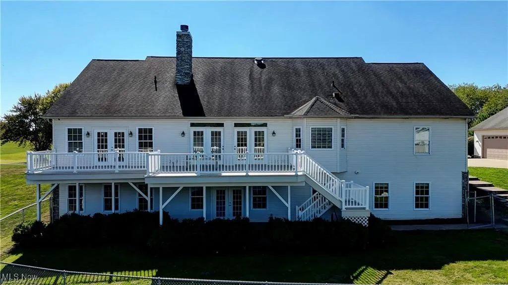 Rear view of property with a fenced backyard, stairway, a deck, a chimney, and french doors