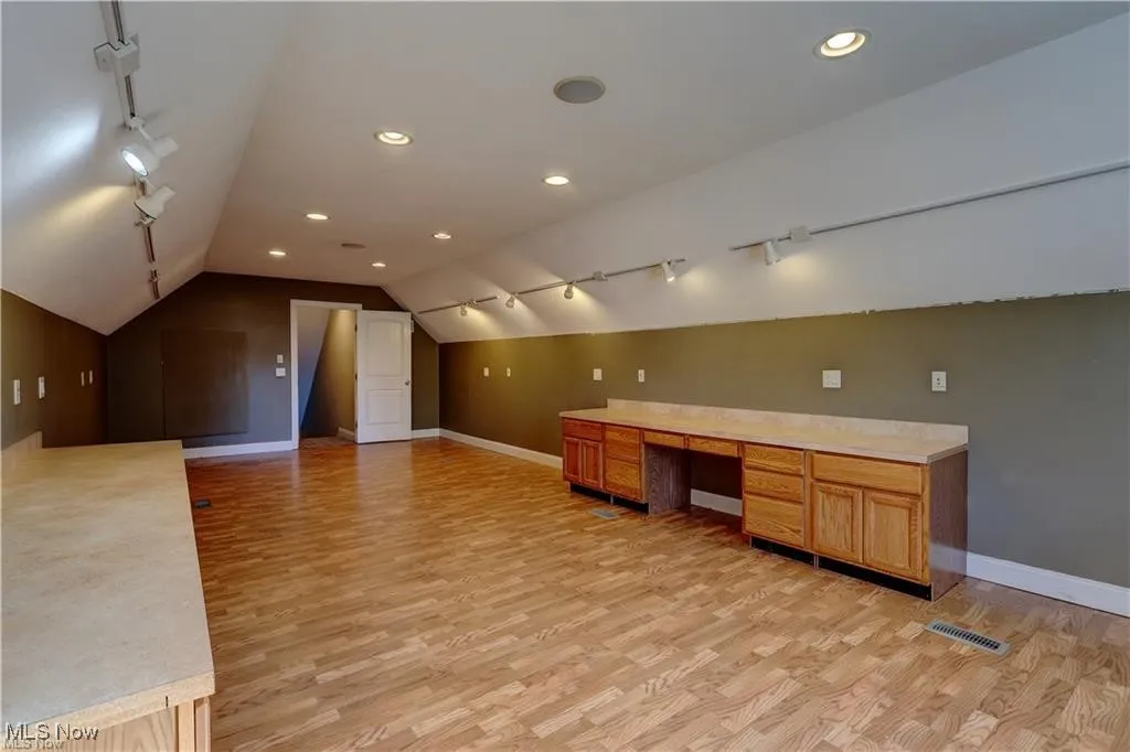 Bonus room featuring light wood-style floors, lofted ceiling, recessed lighting, and a desk