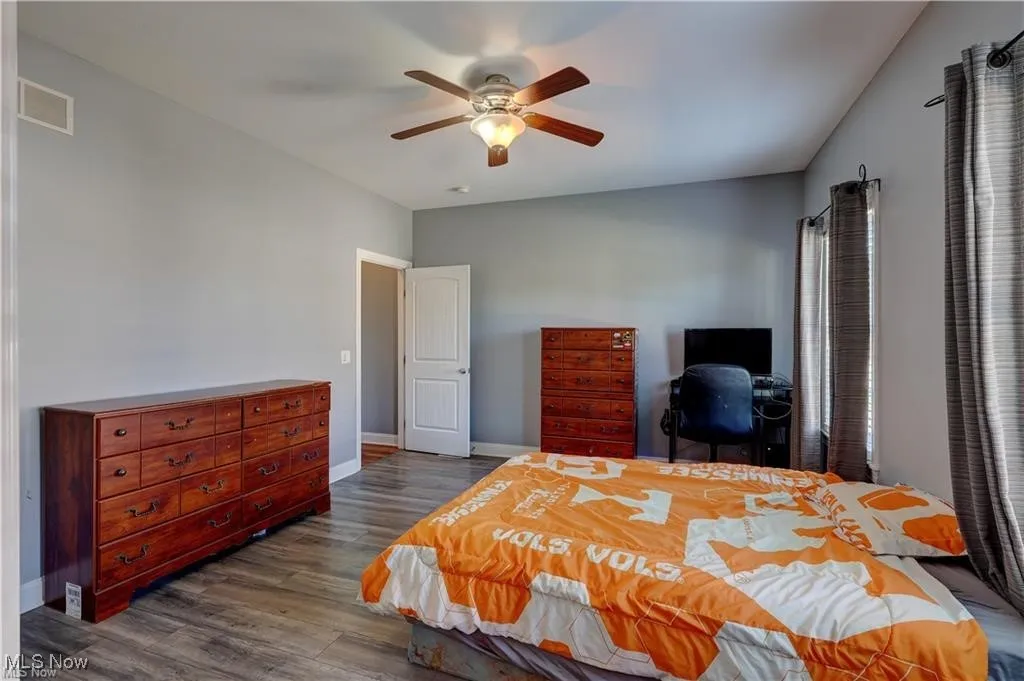 Bedroom with dark wood-style floors and a ceiling fan