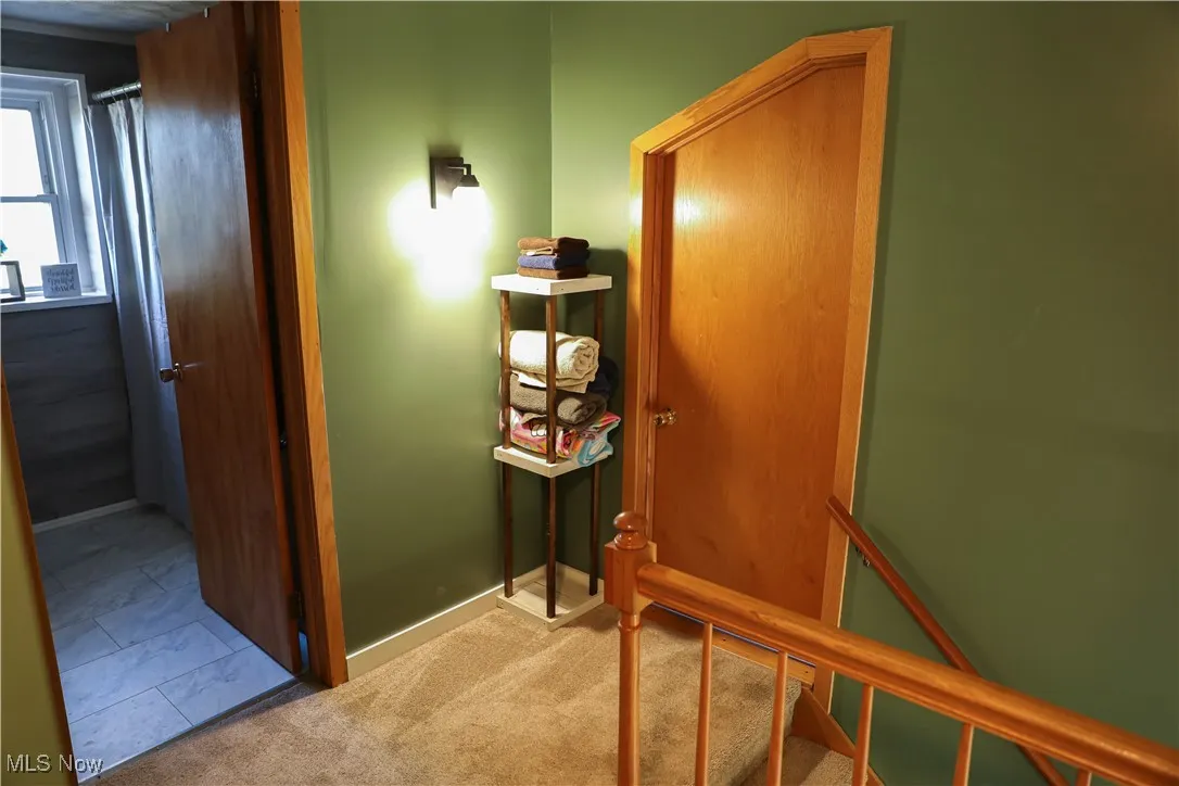 Hall with carpet flooring and baseboards