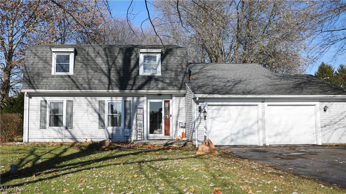 Dutch colonial with roof with shingles, a front lawn, driveway, and a garage