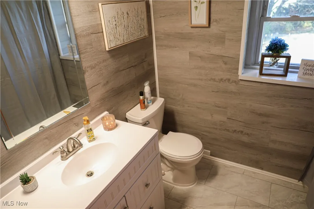 Bathroom with vanity and wooden walls