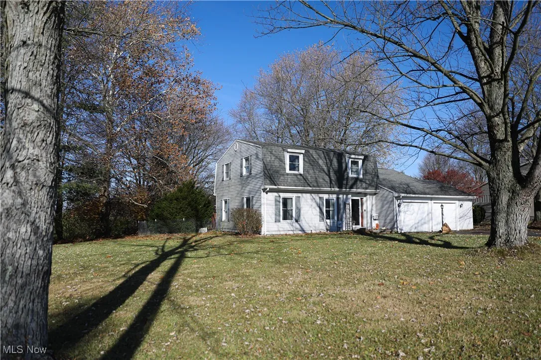 Dutch colonial featuring a gambrel roof, a front yard, and roof with shingles