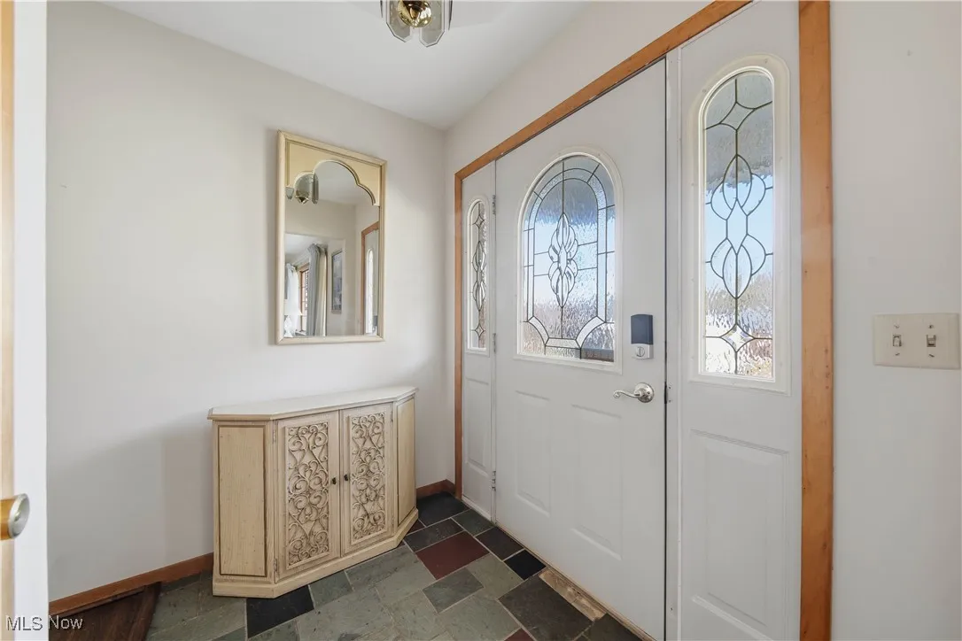 Foyer with stone tile floors and baseboards