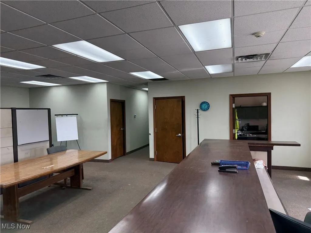 Office space with visible vents, baseboards, and a drop ceiling