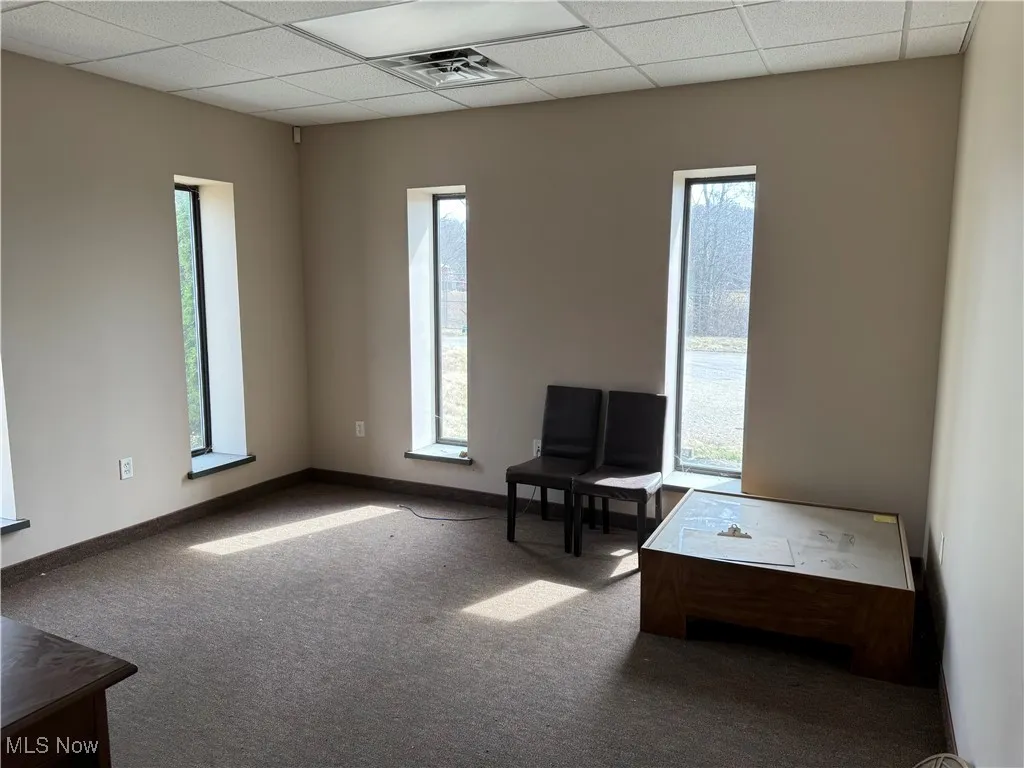 Unfurnished room featuring a paneled ceiling, baseboards, visible vents, and carpet floors