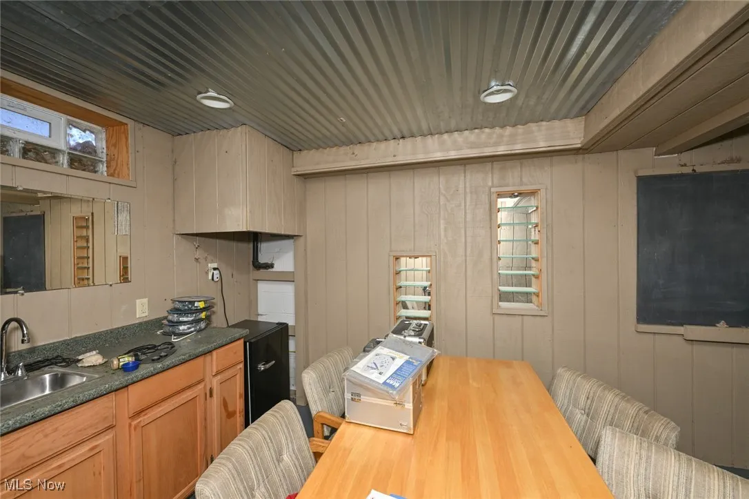 Kitchen featuring wood walls and dark countertops