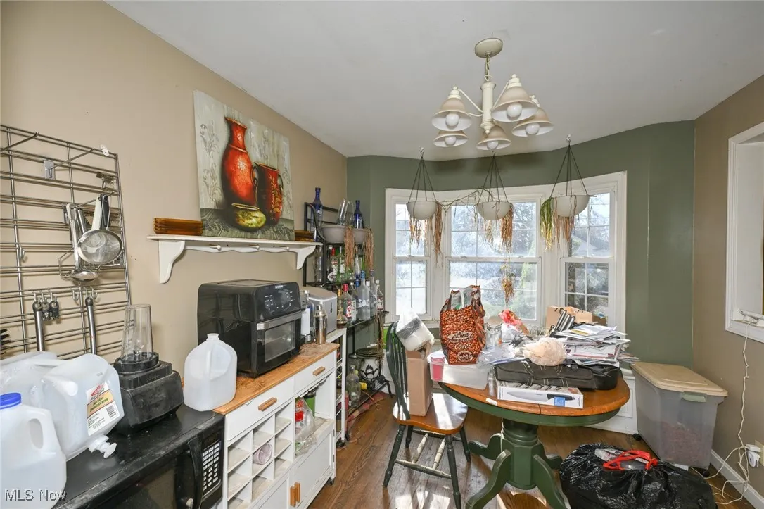 Dining area with a chandelier and dark wood-style flooring