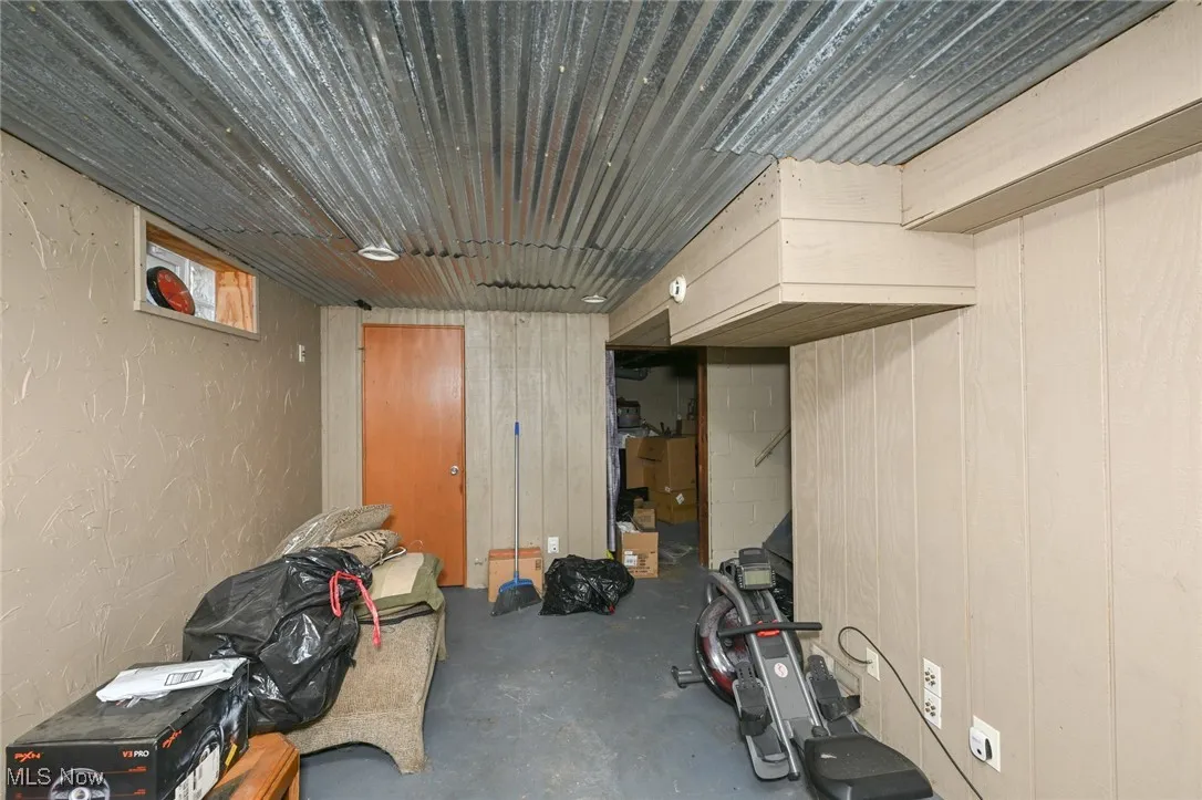 Basement featuring a textured wall and wood walls