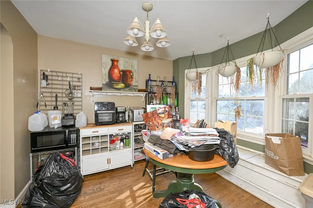 Dining space featuring a chandelier, wood finished floors, and arched walkways