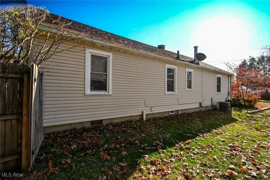 View of side of home with a shingled roof and a central AC unit