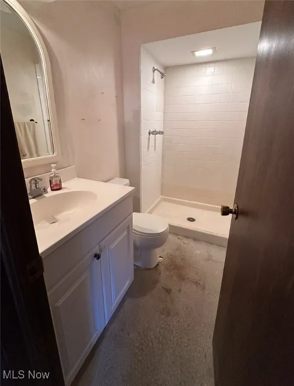 Bathroom featuring vanity, unfinished concrete floors, and a stall shower