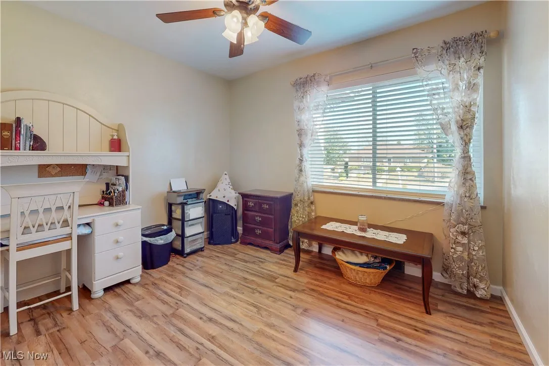 Home office with light wood-style floors and a ceiling fan