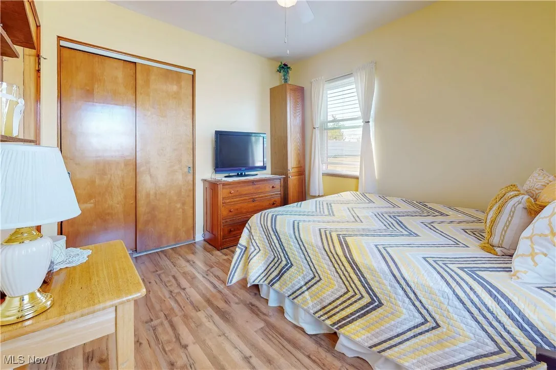Bedroom with light wood-style flooring, a closet, and ceiling fan